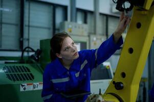 hembra robótica ingeniero trabajando con programación y manipulando robot mano, industrial robótica diseño, alto tecnología instalación, moderno máquina aprendiendo. masa producción automáticas. foto