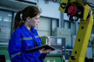 Female Robotics engineer working with Programming and Manipulating Robot Hand, Industrial Robotics Design, High Tech Facility, Modern Machine Learning. Mass Production Automatics. photo