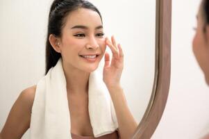 Beautiful asian woman is washing and cleaning her face photo
