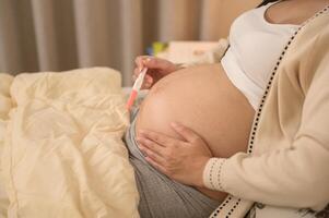 Beautiful pregnant woman holding positive pregnancy test, fertility infertility treatment, IVF, future maternity concept photo