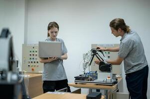 aprendiz robótica ingeniero aprendizaje con programación y manipulando robot mano, industrial robótica diseño, alto tecnología instalación, moderno máquina aprendiendo. masa producción automáticas. foto