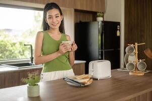 Asian woman preparing coffee and toast bread for breakfast at the kitchen table in the morning photo