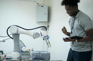 aprendiz robótica ingeniero aprendizaje con programación y manipulando robot mano, industrial robótica diseño, alto tecnología instalación, moderno máquina aprendiendo. masa producción automáticas. foto