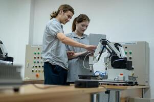 aprendiz robótica ingeniero aprendizaje con programación y manipulando robot mano, industrial robótica diseño, alto tecnología instalación, moderno máquina aprendiendo. masa producción automáticas. foto