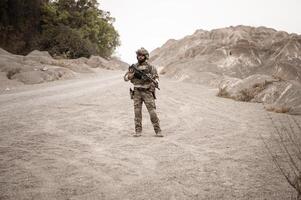 soldados en camuflaje uniformes puntería con su rifles listos a fuego durante militar operación en el Desierto soldados formación en un militar operación foto