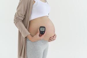 embarazada mujer comprobación sangre azúcar nivel por utilizando digital glucosa metro, salud cuidado, medicamento, diabetes, glicemia concepto foto