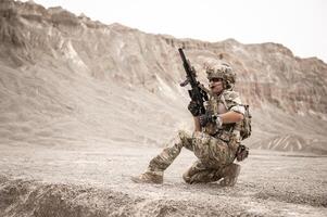 soldados en camuflaje uniformes puntería con su rifles listos a fuego durante militar operación en el Desierto soldados formación en un militar operación foto