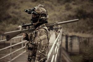 soldados en camuflaje uniformes puntería con su rifles listos a fuego durante militar operación en el bosque soldados formación en un militar operación foto