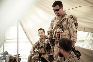 soldados en camuflaje uniformes planificación en operación en el acampar, soldados formación en un militar operación foto