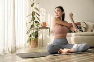 asiático mujer en ropa de deporte hacer ejercicio y haciendo yoga en vivo habitación a hogar, sano estilo de vida, mental salud concepto. foto