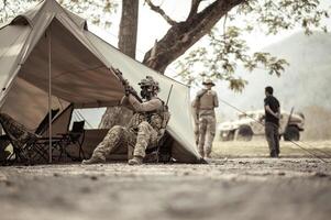 Soldiers in camouflage uniforms planning on operation in the camp, soldiers training in a military operation photo