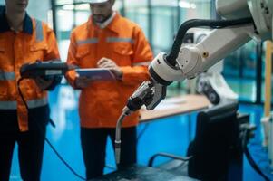 A group of Robotics engineers working with Programming and Manipulating Robot Hand, Industrial Robotics Design, High Tech Facility, Modern Machine Learning. Mass Production Automatics. photo