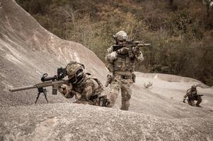 soldados en camuflaje uniformes puntería con su rifles listos a fuego durante militar operación en el Desierto soldados formación en un militar operación foto