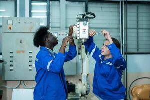 un grupo de robótica ingenieros trabajando con programación y manipulando robot mano, industrial robótica diseño, alto tecnología instalación, moderno máquina aprendiendo. masa producción automáticas. foto