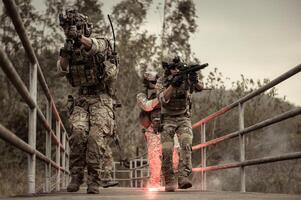 soldados en camuflaje uniformes puntería con su rifles listos a fuego durante militar operación en el bosque soldados formación en un militar operación foto