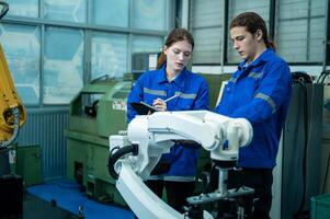 un grupo de robótica ingenieros trabajando con programación y manipulando robot mano, industrial robótica diseño, alto tecnología instalación, moderno máquina aprendiendo. masa producción automáticas. foto