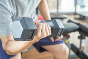 man is lifting the Dumbbell up and down for strengthen her arms and shoulders. exercisers and are checking how to exercise properly. correct exercise. diet, body shape, healthy, strong photo