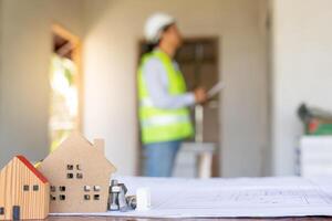 el inspector o ingeniero está inspeccionando la construcción y el aseguramiento de la calidad de la nueva casa usando una lista de verificación. ingenieros o arquitectos o contratistas trabajan para construir la casa antes de entregársela al propietario foto