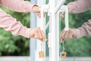 Landlord key for unlocking house is plugged into the door. Second hand house for rent and sale. Owner use hand unlock door mortgage for new home, buy, sell, renovate, investment, owner, estate photo