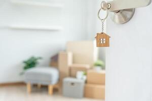 Moving house, relocation. The key was inserted into the door of the new house, inside the room was a cardboard box containing personal belongings and furniture. move in the apartment or condominium photo