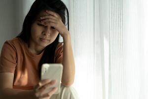 Depression and mental illness. Asian woman disappointed, sad after receiving bad news. Stressed girl confused with unhappy problems, arguing with boyfriend, cry and worry about unexpected pregnancy. photo