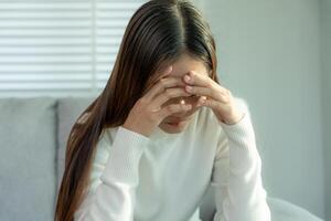 infeliz mujer asiática niña decepcionada, triste por el problema solo en casa, se siente sola, estresada, sufre de mala relación, ruptura, divorcio, mujer confundida, depresión salud mental, soledad foto