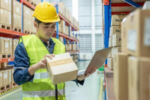 el trabajador del almacén recoge los productos de la caja en el inventario y verifica el producto en stock. entrega de naves comerciales logísticas de transporte al cliente. tarjeta de existencias, lista de materiales, inspección, almacén, almacenamiento, fábrica foto