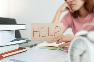 Asian student woman have anxiety because of exams, female prepare for test and learning lessons in the library. stress, despair, haste, misunderstanding reading, discouraged, expectation, knowledge photo