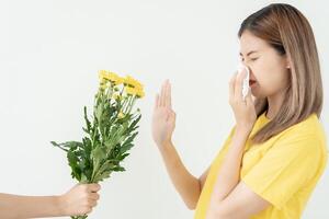 polen alergias, asiático joven mujer estornudos en un pañuelo o soplo en un limpiar, alérgico a salvaje primavera flores o flores durante primavera. alérgico reacción, respiratorio sistema problemas foto