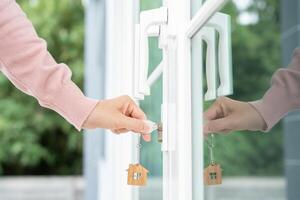 Landlord key for unlocking house is plugged into the door. Second hand house for rent and sale. Owner use hand unlock door mortgage for new home, buy, sell, renovate, investment, owner, estate photo