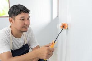 pintor hombre, cepillo en mano para productos a restaurar y pintar el muro, interior el edificio sitio de un casa, pared durante cuadro, renovación, cuadro, contratista, arquitecto, construcción trabajador foto