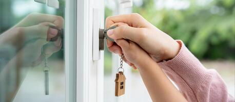 Landlord key for unlocking house is plugged into the door. Second hand house for rent and sale. Owner use hand unlock door mortgage for new home, buy, sell, renovate, investment, owner, estate photo