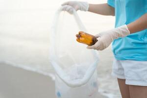 ahorrar agua. los voluntarios recogen basura en la playa y las botellas de plástico son difíciles de descomponer para evitar dañar la vida acuática. tierra, ambiente, planeta verde, reducir el calentamiento global, salvar el mundo foto