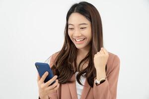 hermosa mujer asiática salió de la expresión de la cara de sorpresa. la mujer se siente sorprendida con el teléfono. sonrisa emocionante y feliz adorable se regocija. muy disfrutar y divertirse relajarse tiempo. guau, chica sosteniendo un teléfono inteligente. foto