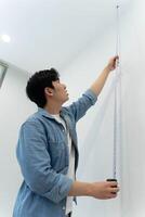 Asian man measuring and repairing houses photo