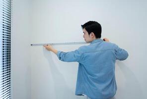 Asian man measuring and repairing houses photo