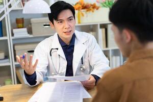 Photo of young Asian male doctor working at office