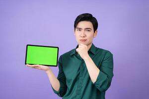 Young Asian business man holding tablet on background photo