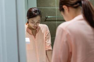 Photo of young Asian woman in bathroom