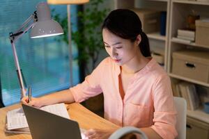 Young Asian woman working at night photo