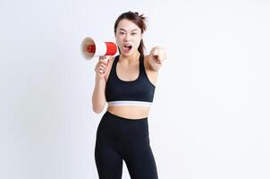 joven asiático mujer vistiendo ropa de deporte en blanco antecedentes foto