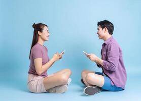 joven asiático Pareja en azul antecedentes foto