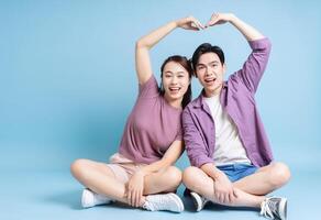 Young Asian couple on blue background photo