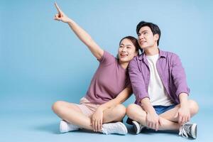 Young Asian couple on blue background photo