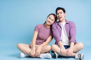 Young Asian couple on blue background photo