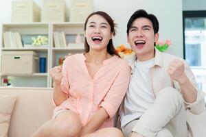 Photo of young Asian couple at home