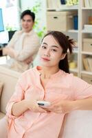 Photo of young Asian couple at home