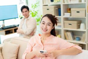 Photo of young Asian couple at home