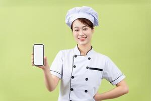 Photo of young Asian female chef on background