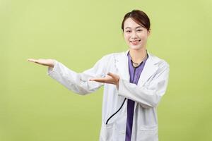 Photo of young Asian femle doctor on green background